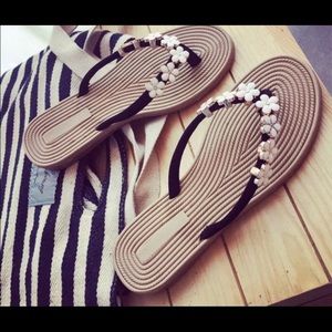 Flip-flops/ Sandals with flower charms.